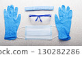 Medical face mask, glasses, hat and gloves laying on table flat lay view with copy-space 130282286