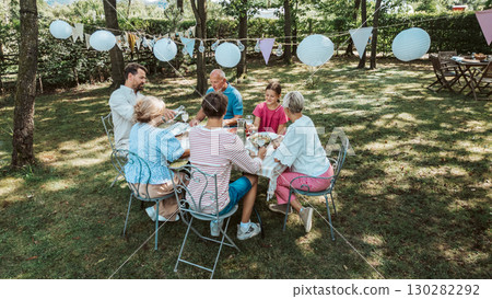 Aerial shot of family gathering for barbecue in summer garden. 130282292