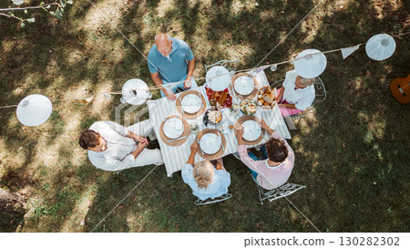 Areal view of grandparents, parents and kids dining together outside. 130282302
