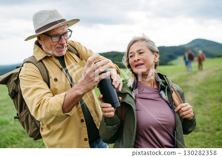 Older couple on group trip in autumn nature. 130282358