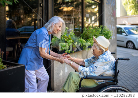 Tender moment between older caregiver and senior female patient in wheelchair. Tender moment between older caregiver and senior female patient in wheelchair. 130282398