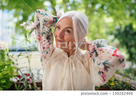 Portrait of beautiful senior woman standing on balcony. 130282408