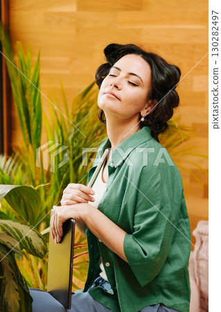Portrait of woman with hair rollers during slow morning. 130282497