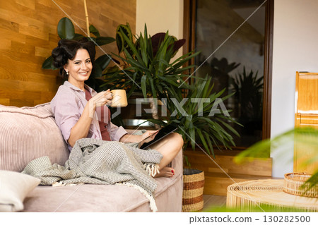 Portrait of woman with hair rollers during slow morning. 130282500