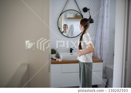 Teenager looking at her body in mirror. Body Image concept. Teenager looking at her body in mirror. Body Image concept. 130282503