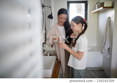 Mother talking with daughter during skincare routine Mother talking with daughter during skincare routine 130282509