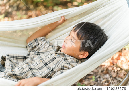 兒童、小學生、男孩在露營地的吊床上玩耍（戶外、旅行、休閒、野餐） 130282578