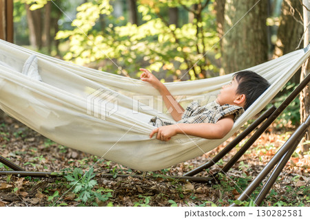 兒童、小學生、男孩在露營地的吊床上玩耍（戶外、旅行、休閒、野餐） 130282581