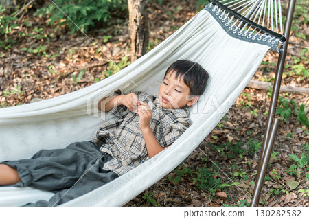 兒童、小學生、男孩在露營地的吊床上玩耍（戶外、旅行、休閒、野餐） 130282582