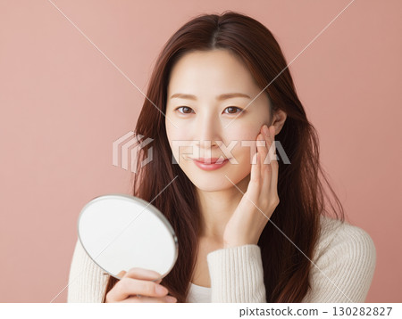 二十多歲女性在護膚過程中檢查裸露皮膚的美容圖片（美容和健康廣告） 130282827