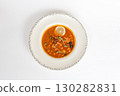 Rich soup with smoked meats, sausages, lemon, and olives, viewed from above on a white background 130282831