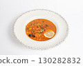 Rich soup with smoked meats, sausages, lemon, and olives on a white background 130282832