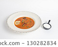 Rich soup with smoked meats, sausages, lemon, and olives on a white background 130282834
