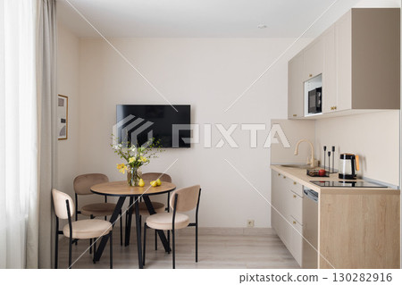This modern kitchenette features a delightful dining space, creating a cozy atmosphere 130282916