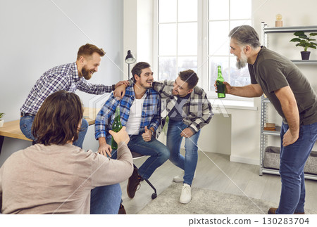 Group of happy male friends drinking beer at home Group of happy male friends drinking beer at home 130283704