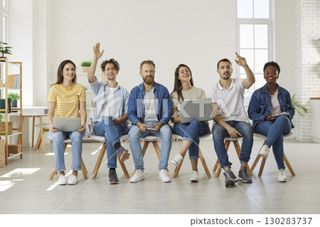 Group of students or colleagues raising their hands to ask questions at meeting Group of students or colleagues raising their hands to ask questions at meeting 130283737