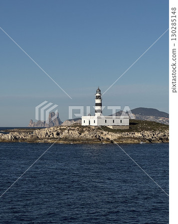 White lighthouse on rocky coastline in Formentera 130285148