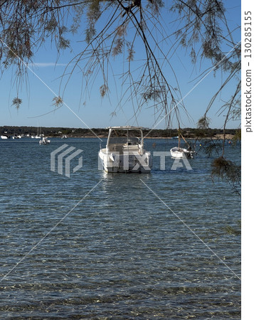 Tree framing view of boats in Formentera bay Tree framing view of boats in Formentera bay 130285155