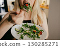 Blonde woman enjoying healthy meal of fresh salad with arugula, peach, cucumber, cheese, promoting balanced diet and mindful eating habits. Blonde woman eating fresh salad. Nutritious dietary choices 130285271