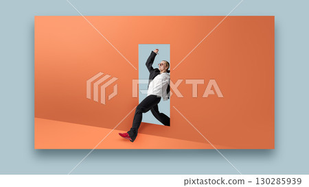 Contemporary collage of businesswoman stepping through doorway on orange wall with red shoes and joyful fashion energy 130285939
