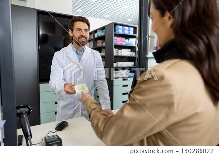 Young dark-haired caucasian woman buying medicines in the pharmacy 130286022