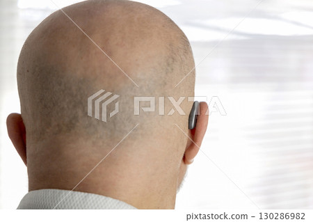 Male head from back with hearing aid on ear Male head from back with hearing aid on ear 130286982
