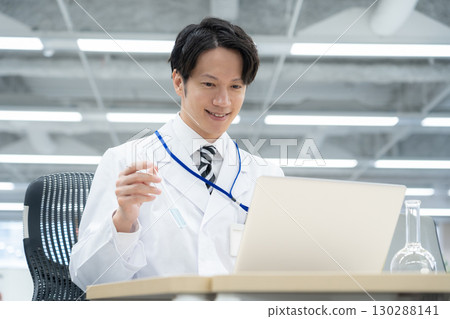 一位身穿白大褂的年輕男研究員在實驗室進行實驗 130288141