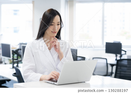 一位身穿白大褂的年輕女研究員在實驗室進行實驗 130288197