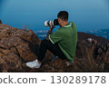 Photographer with Telephoto Lens Shooting at Mountain Sunset 130289178