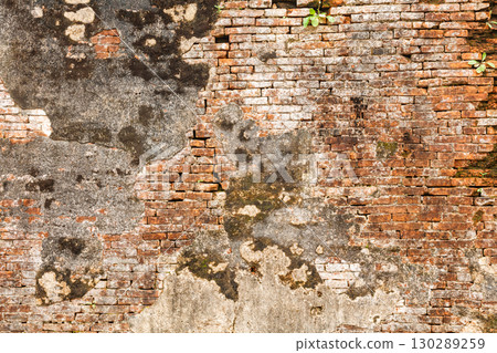 Close-up of old weathered brick wall with peeling plaster and moss in Hue Imperial City Vietnam Close-up of old weathered brick wall with peeling plaster and moss in Hue Imperial City Vietnam 130289259