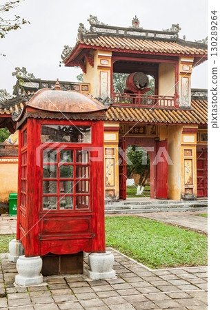 Red wooden pavilion and traditional Vietnamese gate with ceremonial drum in Hue Imperial City 130289264