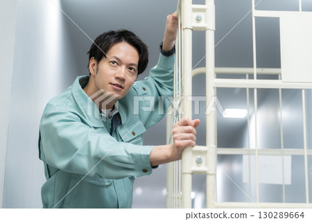 一名年輕男工人在倉庫搬運行李 130289664