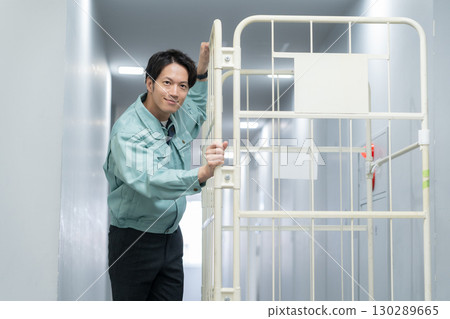 一名年輕男工人在倉庫搬運行李 130289665
