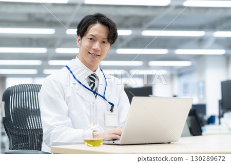 一位身穿白大褂的年輕男研究員在實驗室進行實驗 130289672