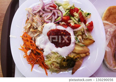 Meat with potatoes, vegetables and sauce view from above. Shawarma on a plate Meat with potatoes, vegetables and sauce view from above. Shawarma on a plate 130290056