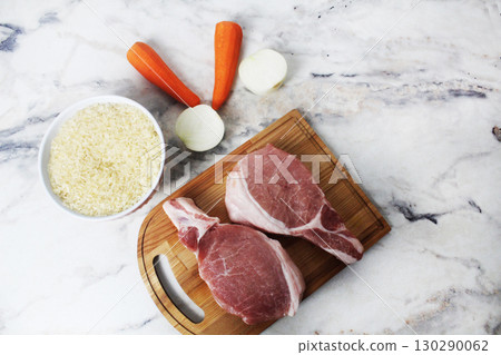 Meat, rice and vegetables on a light background, top view. Preparing lunch 130290062
