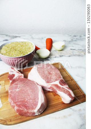 Raw meat and rice on the table side view. Background for a meat and rice recipe 130290063