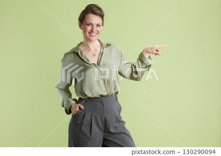 Presenting woman in green Presenting woman in green 130290094