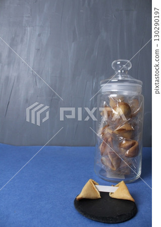 Fortune cookies in a jar bowl on a blue copy space background. Prediction text in cookies. Holiday traditions. Chinese Traditions 130290197