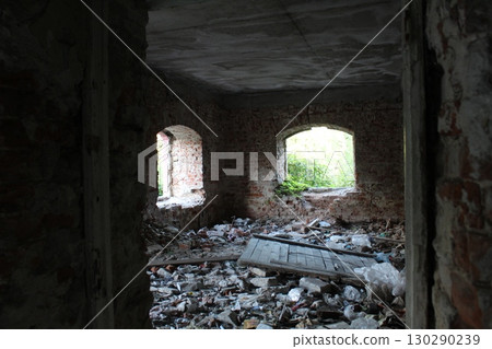 a room in an old ruined house with fragments of brick and plaster 130290239