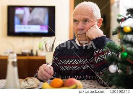 Sad bored older man in warm knitted sweater celebrating New Year 130290243