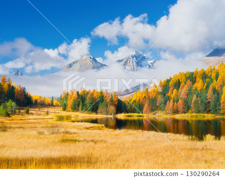 Autumn landscape. Nature. Clouds over the mountains and fall forest. Lake and reflection. Autumn landscape. Nature. Clouds over the mountains and fall forest. Lake and reflection. 130290264
