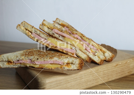 Food, avtrak. Sandwiches with ham cheese and vegetable elenium lie on a gray plate next to the juice of orange apricot on the table. Cooking breakfast Food, avtrak. Sandwiches with ham cheese and vegetable elenium lie on a gray plate next to the juice of orange apricot on the table. Cooking breakfast 130290479