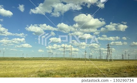 Many high-voltage transmission tower and electricity pylon power lines against blue sky with cloud 130290734