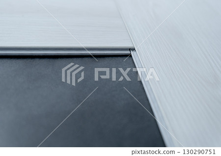 A man lays a quartz laminate on the floor. Renovation, Installation of French herringbone 130290751