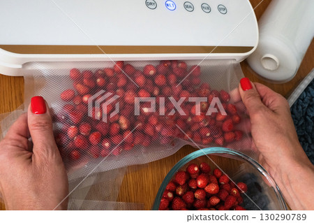 Vacuum sealer of strawberries, honeysuckle in bag, packaging for long-term storage . Vacuum packing machine Vacuum sealer of strawberries, honeysuckle in bag, packaging for long-term storage . Vacuum packing machine 130290789
