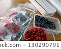 Vacuum sealer of strawberries, honeysuckle in bag, packaging for long-term storage . Vacuum packing machine 130290791