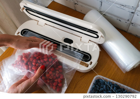 Vacuum sealer of strawberries, honeysuckle in bag, packaging for long-term storage . Vacuum packing machine 130290792