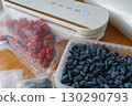 Vacuum sealer of strawberries, honeysuckle in bag, packaging for long-term storage . Vacuum packing machine 130290793