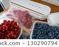 Vacuum sealer of strawberries, honeysuckle in bag, packaging for long-term storage . Vacuum packing machine 130290794